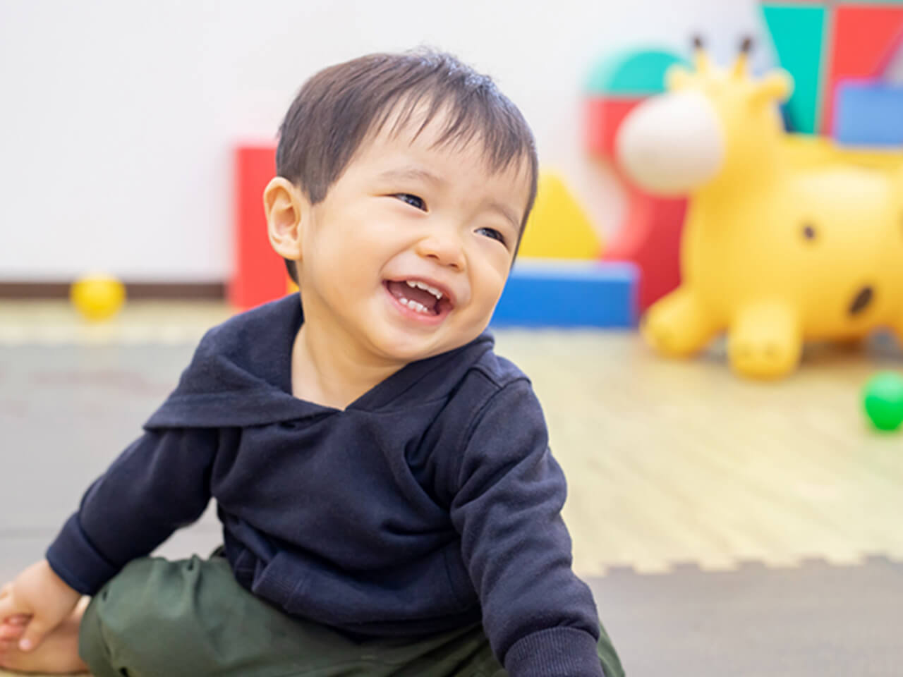 室内で遊ぶ幼い男の子の笑顔のクローズアップ写真